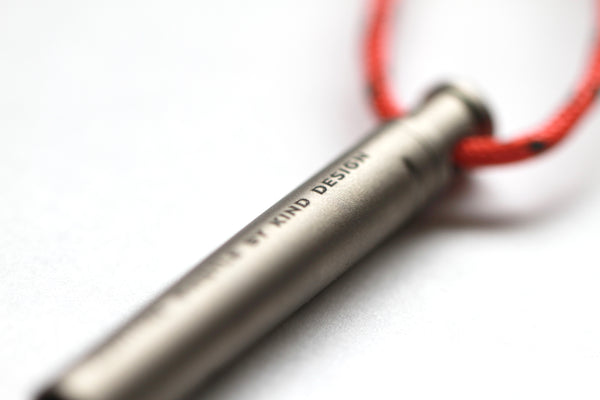 Survival Whistle by Kind Design - close-up of engraved lettering on titanium
